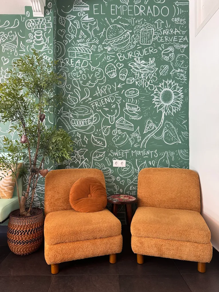 Rincón con sillones naranja y mural de El Empedrado